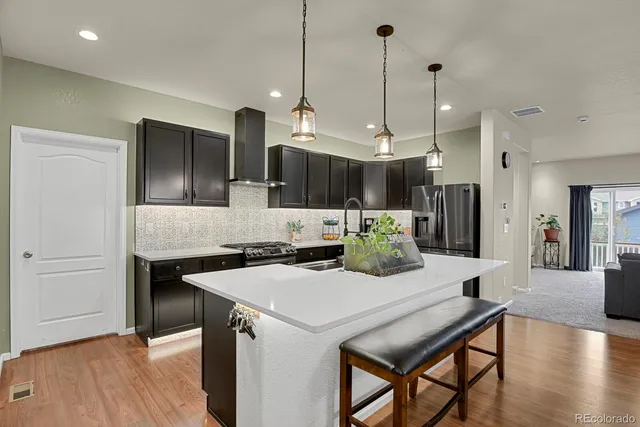 a kitchen with a table chairs refrigerator and microwave