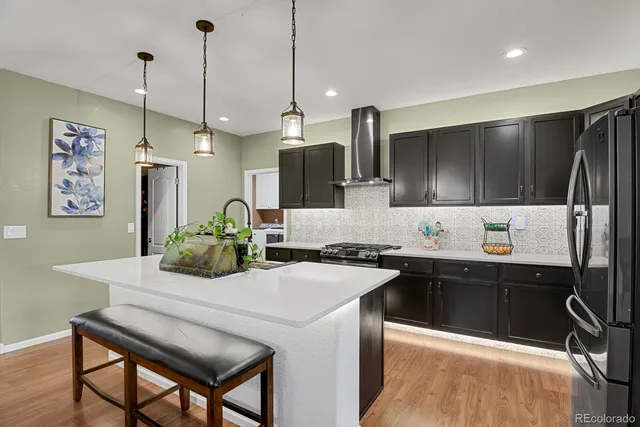 a kitchen with stainless steel appliances a sink a stove a refrigerator and island