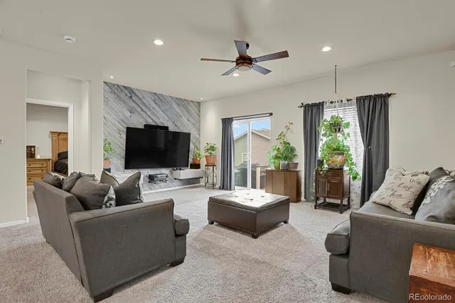 a living room with furniture a flat screen tv and a large window