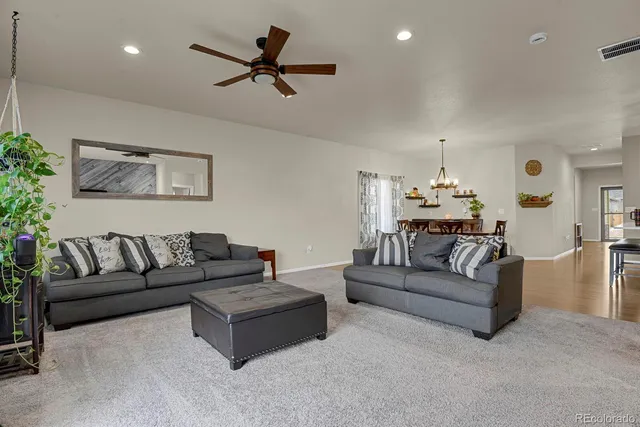 a living room with furniture and a ceiling fan