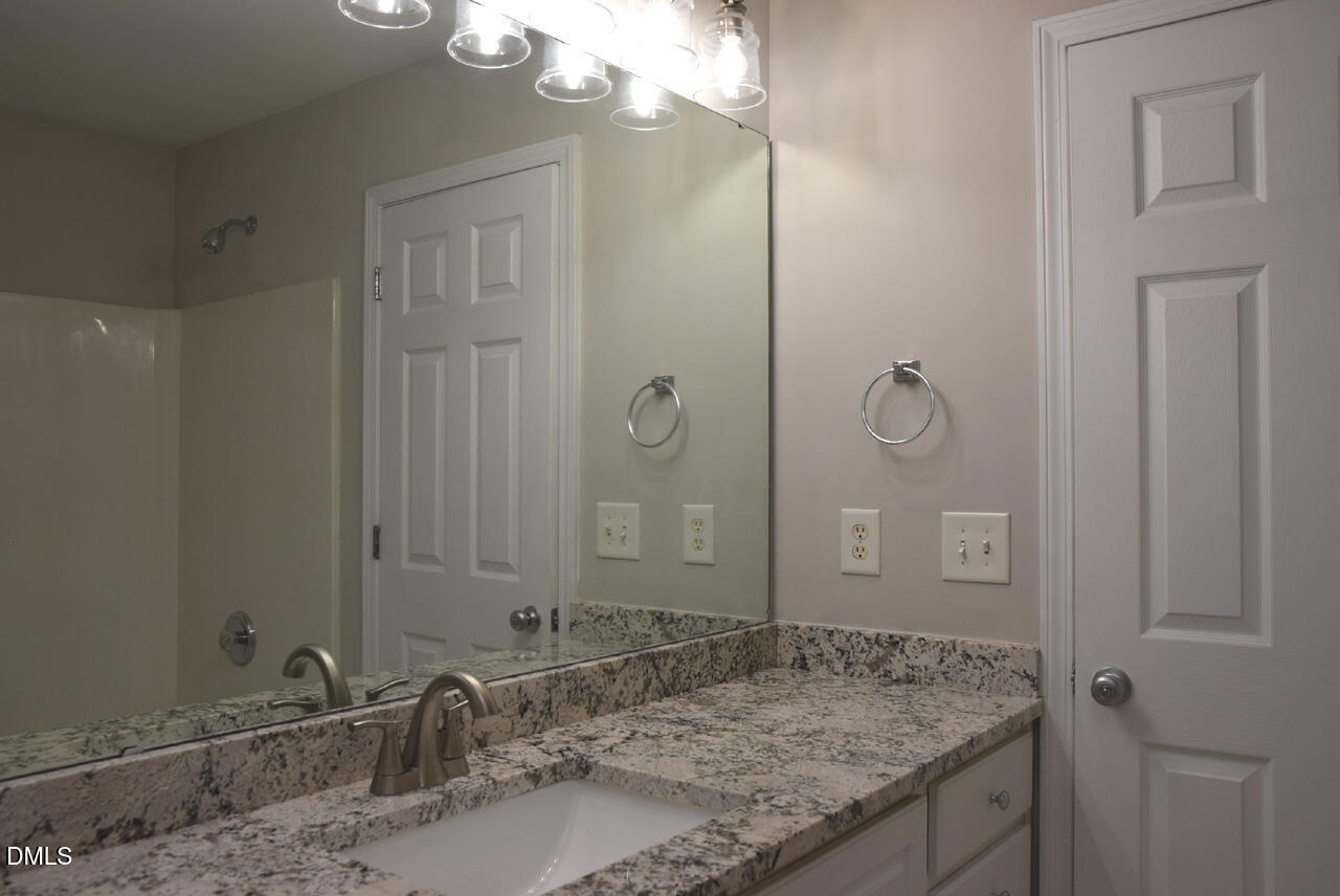 8269 City Loft Court Raleigh, NC 27613 - Photo 16 of 26 a bathroom with a granite countertop sink and a mirror
