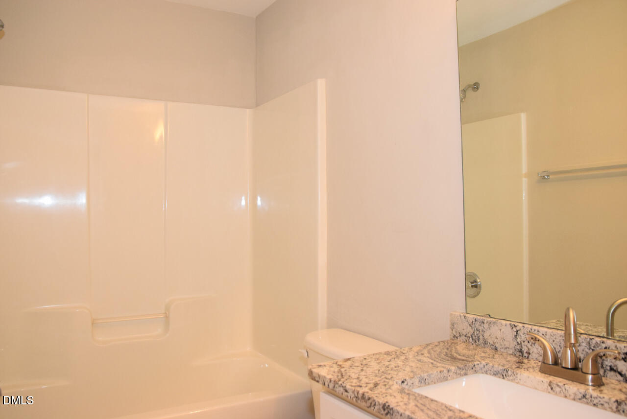 8269 City Loft Court Raleigh, NC 27613 - Photo 22 of 26 a bathroom with a granite countertop sink and a mirror