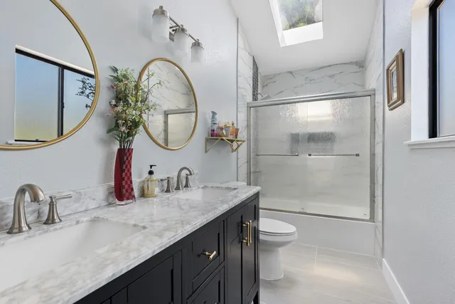 a bathroom with a double vanity sink mirror and toilet