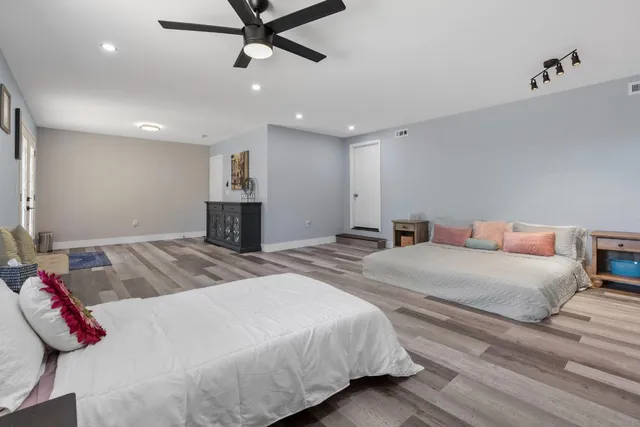 a bedroom with a large bed and a chandelier