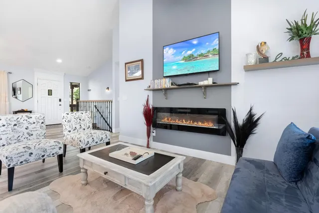 a living room with furniture a flat screen tv and a fireplace