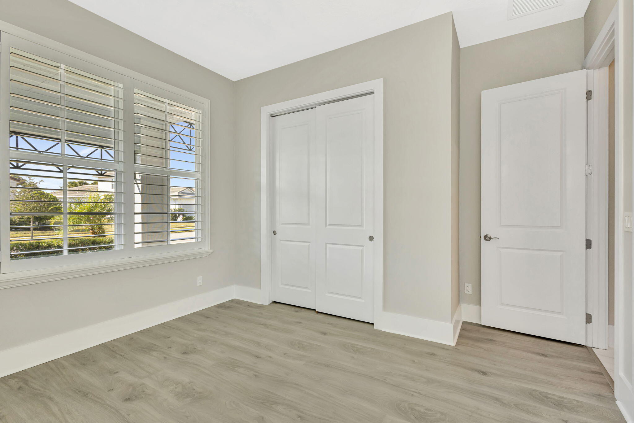 11953 Southwest Vano Way Port Port St. Lucie, FL 34987 - Photo 24 of 74 a view of an empty room with wooden floor and a window