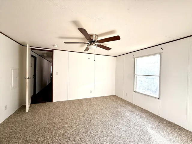 a view of a big room with a ceiling fan and a window