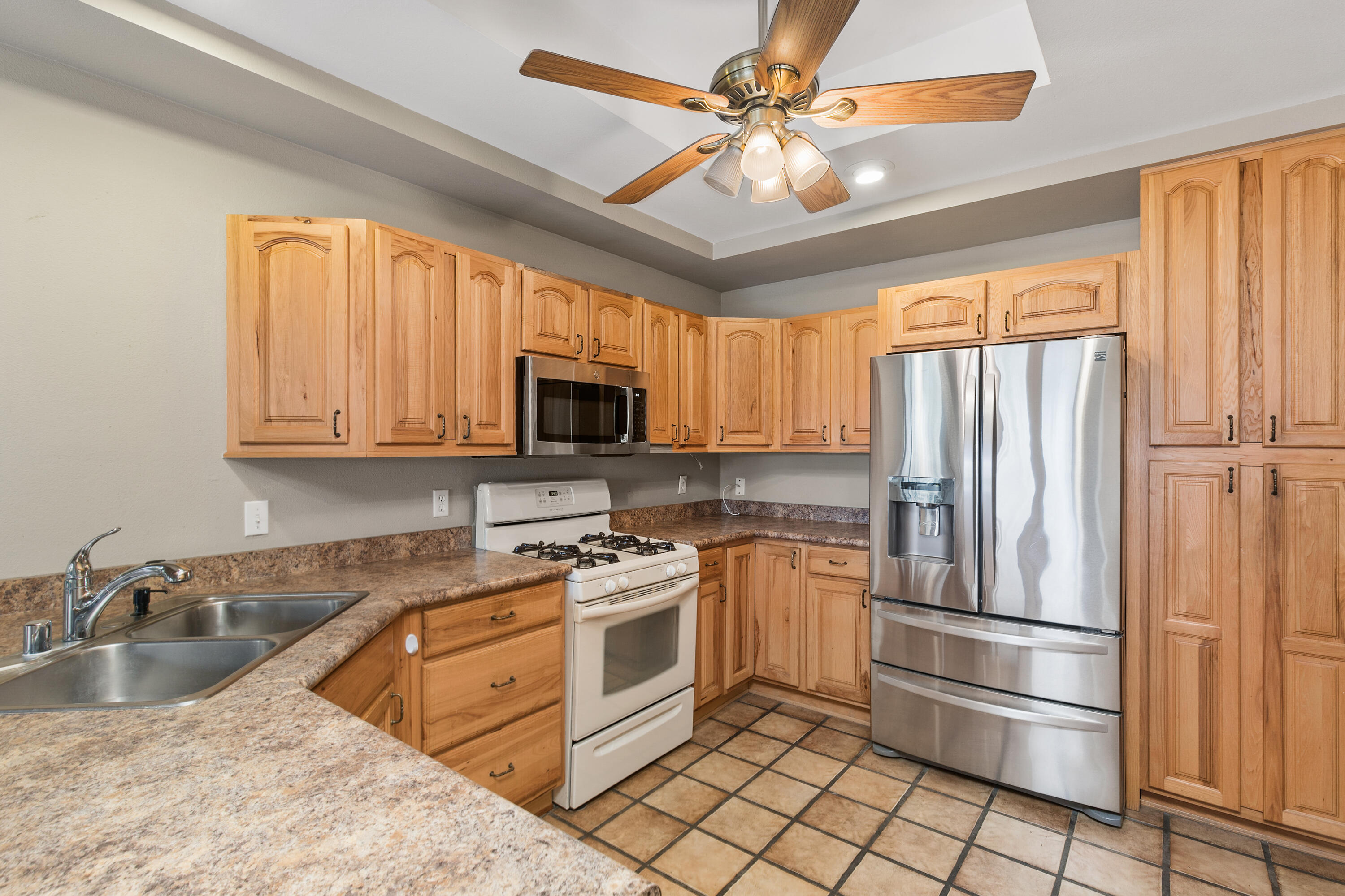 722 Inverness Drive Rancho Mirage, CA 92270 - Photo 5 of 59 a kitchen with stainless steel appliances granite countertop a refrigerator a stove a sink and a microwave