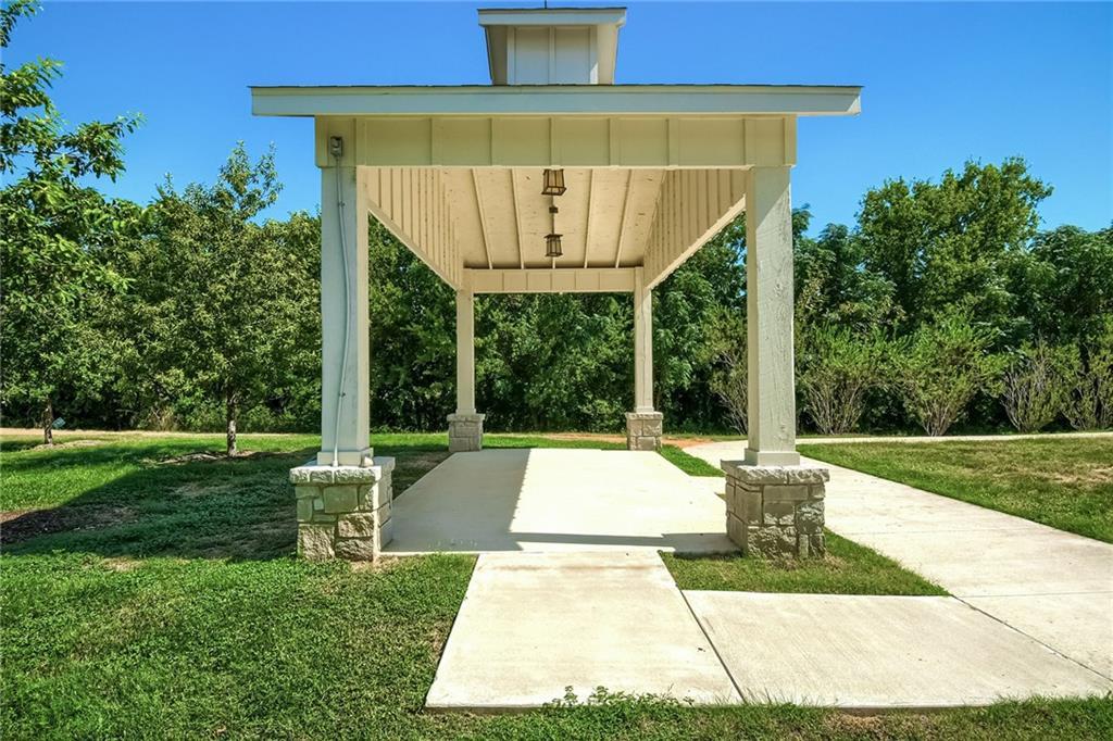 2624 Metcalfe Road, Unit 7 Austin, TX 78741 - Photo 28 of 31 Covered outdoor structure with stone-clad column bases, painted wood posts, and a beadboard ceiling