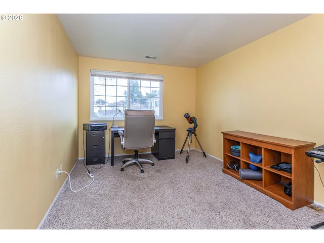 a view of a workspace with furniture and a window