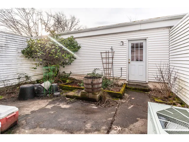 a backyard of a house with barbeque oven table and chairs