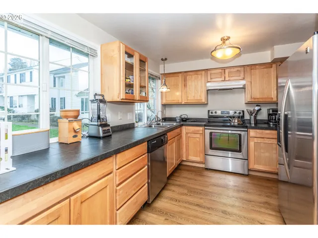 a kitchen with stainless steel appliances granite countertop a stove a sink and a refrigerator
