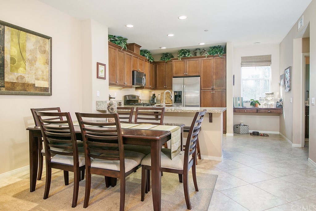 15205 Fairfax Way Tustin, CA 92782 - Photo 10 of 28 a dining area with stainless steel appliances kitchen island granite countertop a dining table chairs and a refrigerator