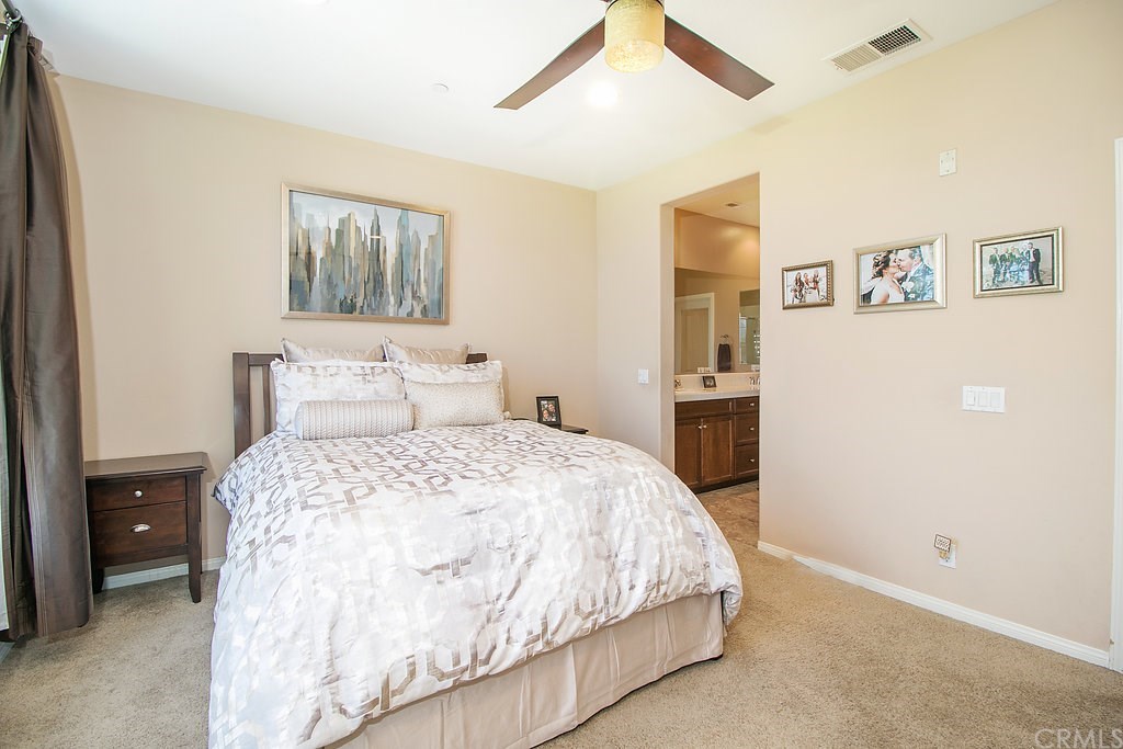 15205 Fairfax Way Tustin, CA 92782 - Photo 17 of 28 a bedroom with a large bed and a chandelier