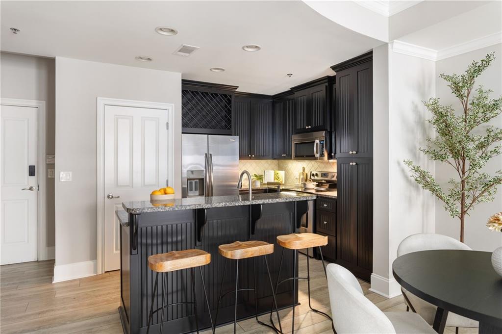 2255 Peachtree Road Northeast, Unit 326 Atlanta, GA 30309 - Photo 17 of 37 a kitchen with granite countertop a dining table chairs and a refrigerator