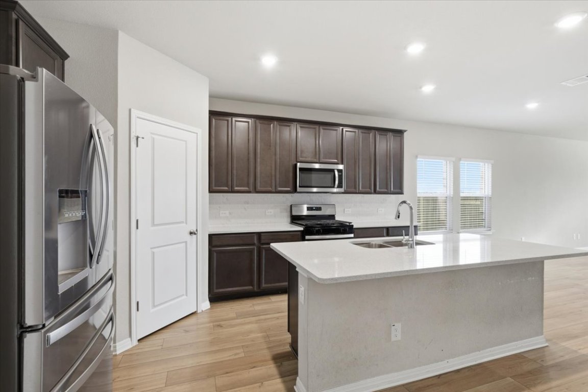 17705 Prairie Land Way Manor, TX 78653 - Photo 6 of 29 a kitchen with stainless steel appliances granite countertop a refrigerator sink and stove