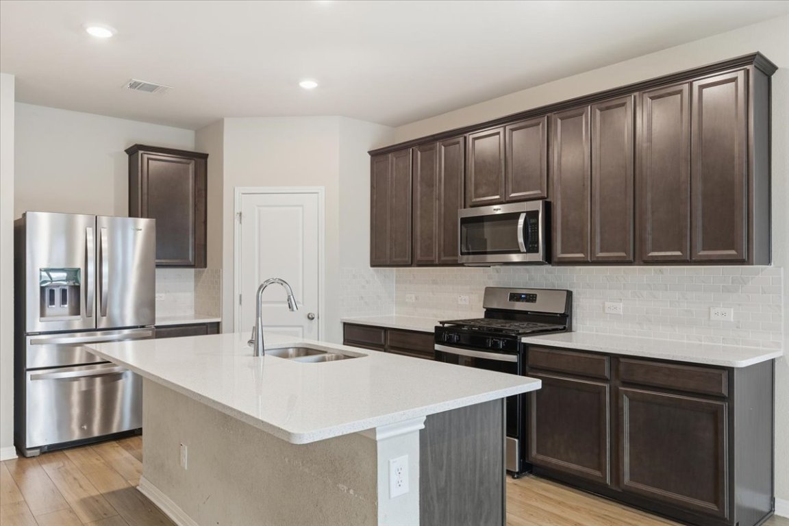 17705 Prairie Land Way Manor, TX 78653 - Photo 7 of 29 a kitchen with a sink stove and microwave