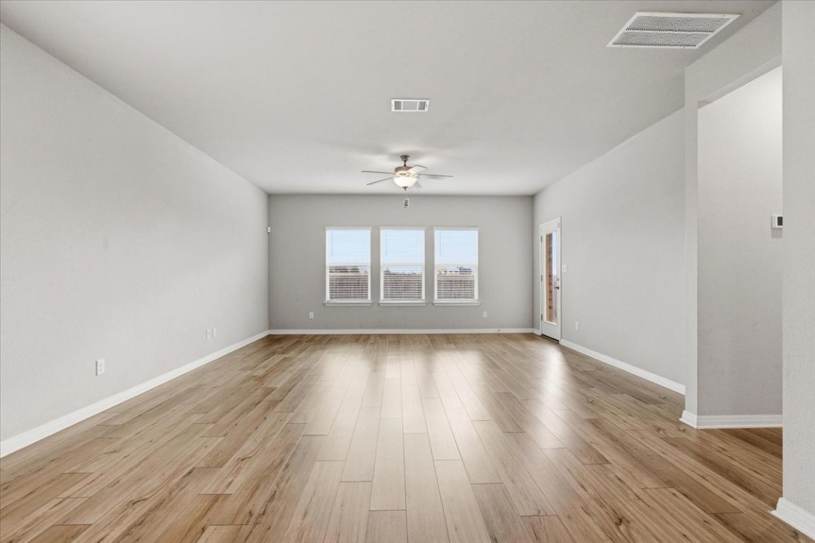 17705 Prairie Land Way Manor, TX 78653 - Photo 8 of 29 a view of an empty room with wooden floor and a window