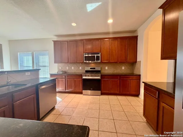 a kitchen with stainless steel appliances granite countertop a refrigerator and a sink