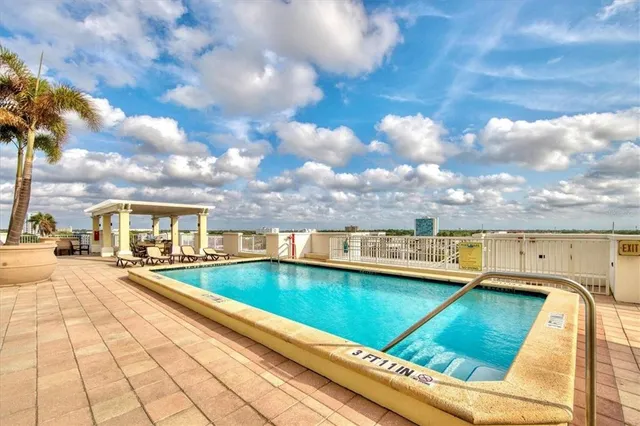 a view of swimming pool with a lounge chair in front of house