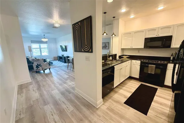 a kitchen with granite countertop a stove top oven and cabinets