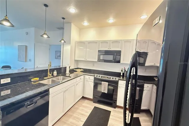 a kitchen with a sink appliances and cabinets