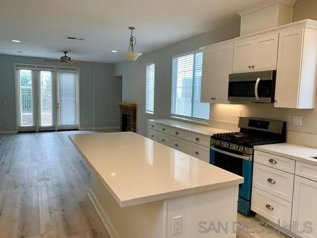 6921 Catamaran Drive Carlsbad, CA 92011 - Photo 22 of 26 a kitchen with a stove a sink and a microwave