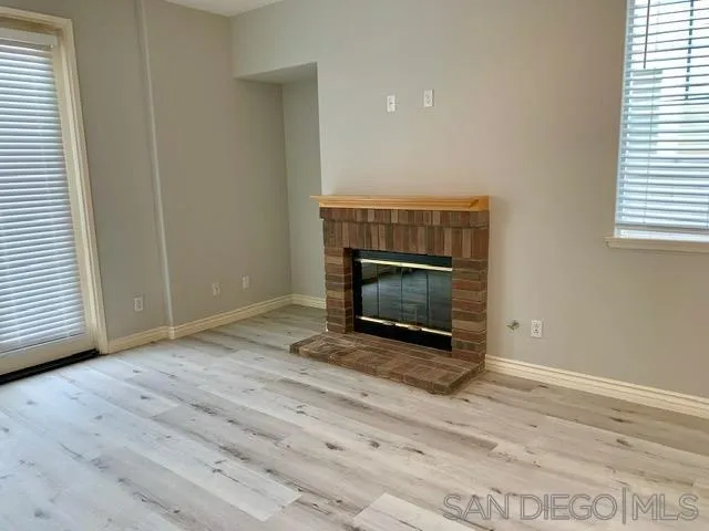 6921 Catamaran Drive Carlsbad, CA 92011 - Photo 23 of 26 an empty room with wooden floor fireplace and windows