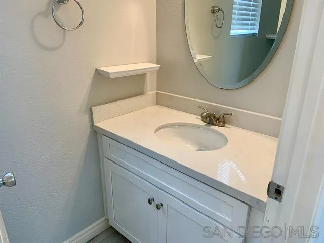 6921 Catamaran Drive Carlsbad, CA 92011 - Photo 24 of 26 a bathroom with a sink and mirror