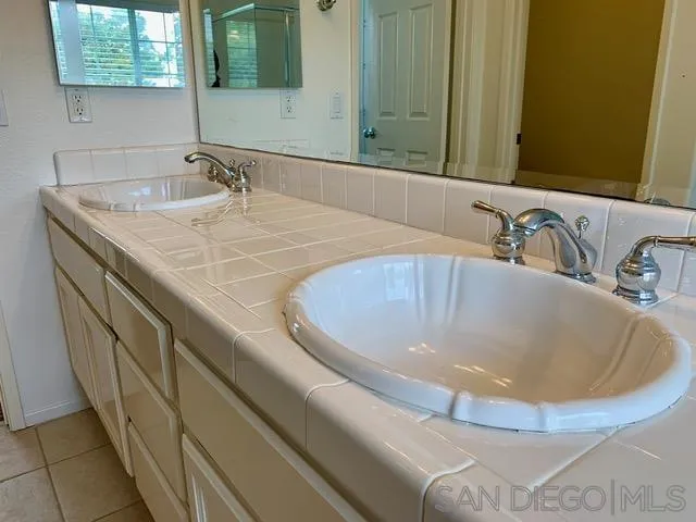 6921 Catamaran Drive Carlsbad, CA 92011 - Photo 4 of 26 a bathroom with a sink and a mirror
