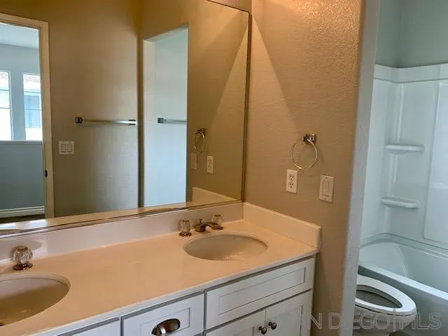 6921 Catamaran Drive Carlsbad, CA 92011 - Photo 10 of 26 a bathroom with a sink and a mirror
