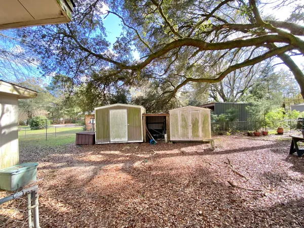 a view of a house with a yard and a large tree