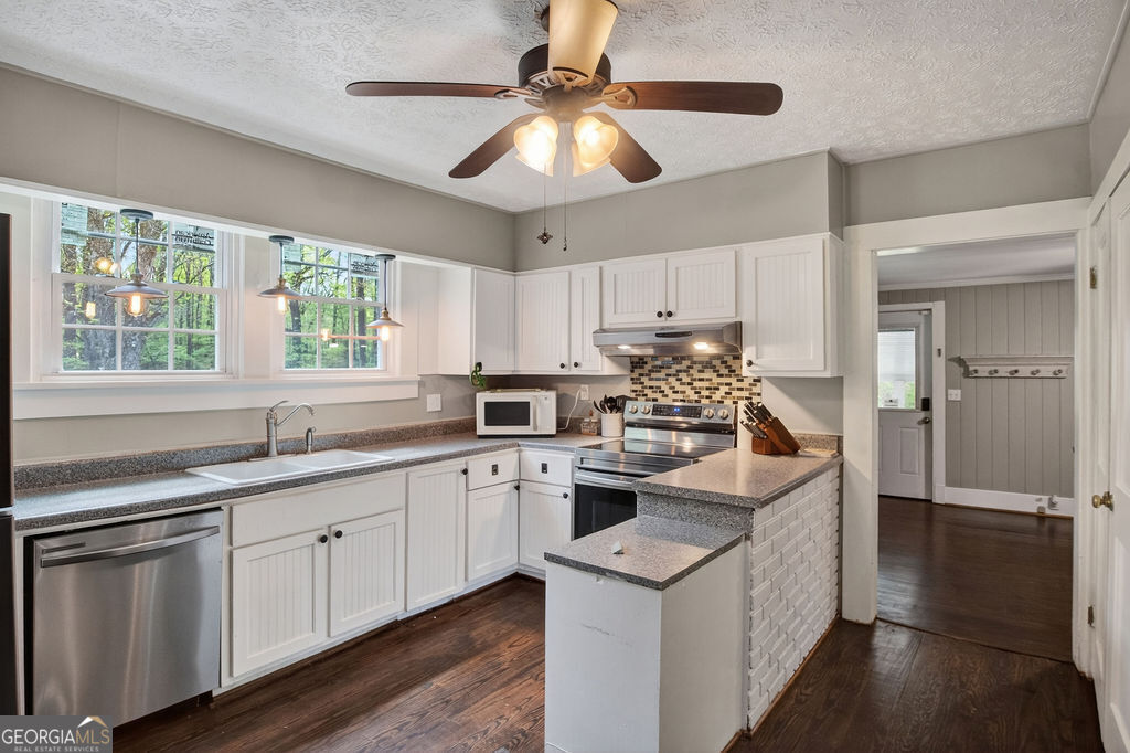 2051 Emmett Doster Road Northwest Monroe, GA 30656 - Photo 11 of 50 a kitchen with a sink stove and cabinets