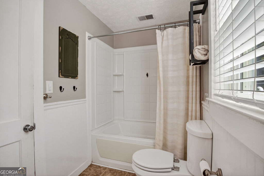 2051 Emmett Doster Road Northwest Monroe, GA 30656 - Photo 20 of 50 a bathroom with a shower a toilet and a window