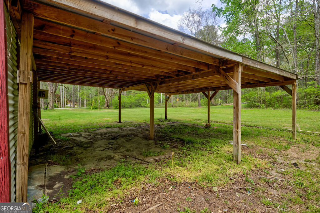 2051 Emmett Doster Road Northwest Monroe, GA 30656 - Photo 39 of 50 a view of a backyard with table and chairs under an umbrella