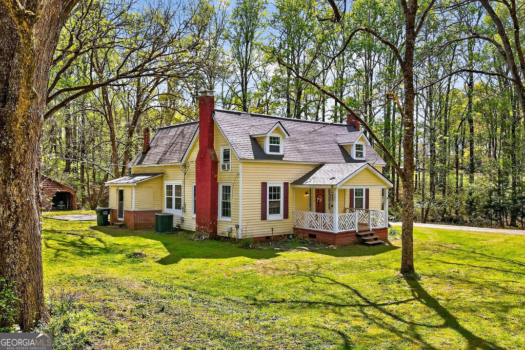 2051 Emmett Doster Road Northwest Monroe, GA 30656 - Photo 49 of 50 a front view of a house with a yard table and chairs