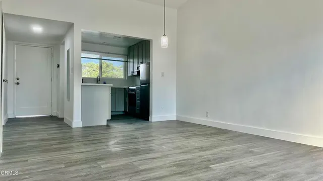 a view of an empty room with closet and wooden floor
