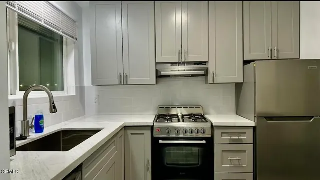 a kitchen with stainless steel appliances granite countertop a sink stove and refrigerator