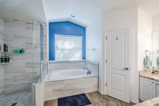 a bathroom with a bathtub a sink a vanity and a window