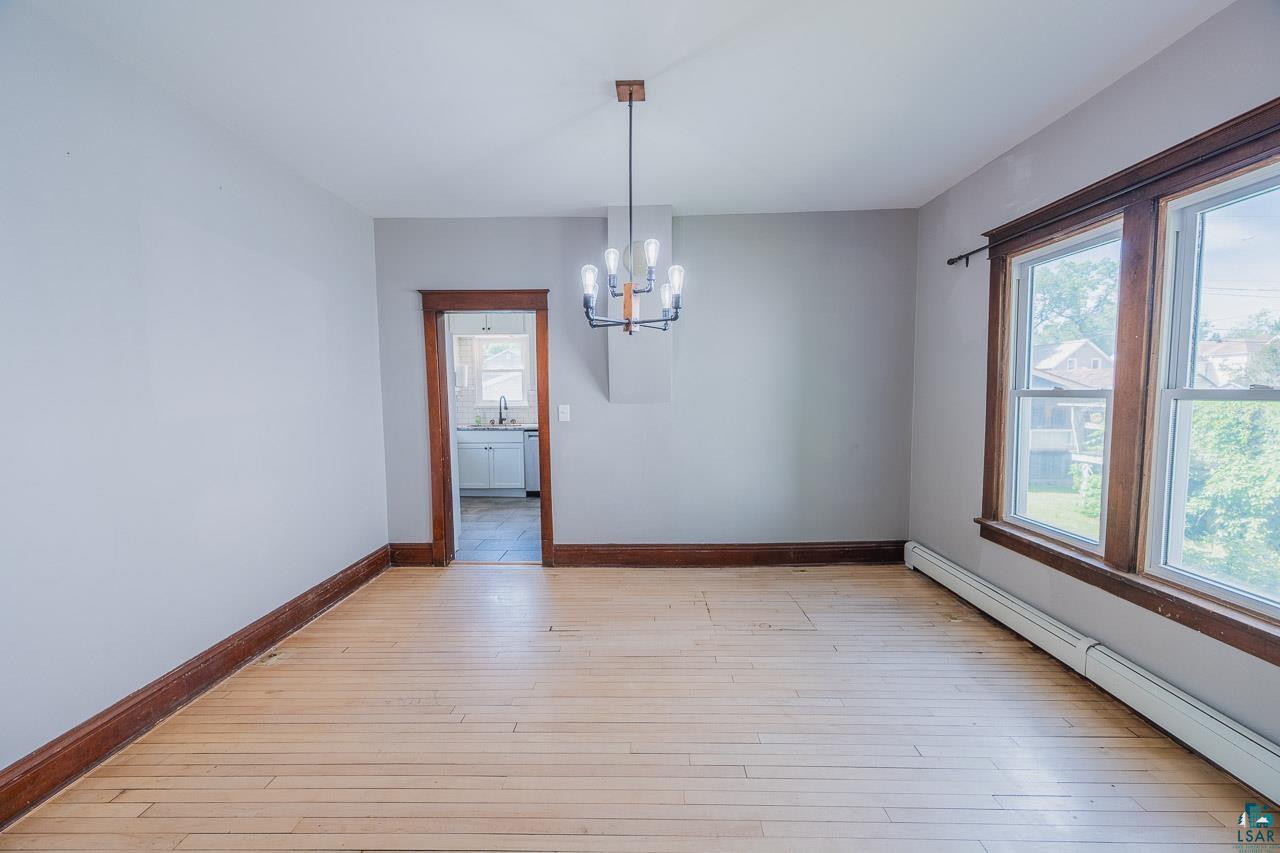 508 10th Street South Virginia, MN 55792 - Photo 7 of 43 Hardwood flooring with dark wood trim, featuring a contemporary ceiling fixture