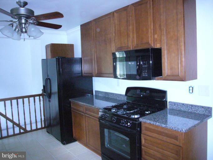 317 Worthington Road Towson, MD 21286 - Photo 8 of 14 a kitchen with stainless steel appliances granite countertop a stove and a microwave