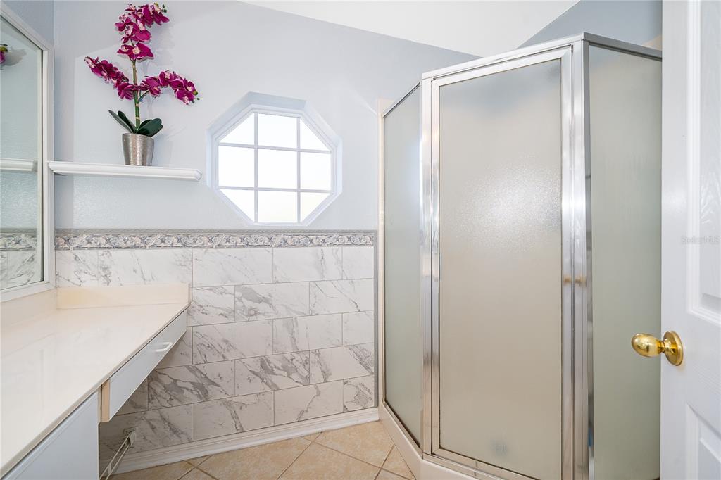 611 Baldwin Drive Kissimmee, FL 34758 - Photo 15 of 26 a bathroom with a granite countertop shower a sink and a mirror