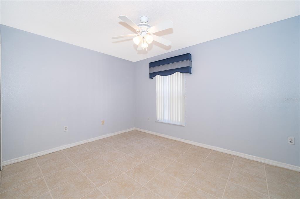 611 Baldwin Drive Kissimmee, FL 34758 - Photo 19 of 26 an empty room with windows and ceiling fan