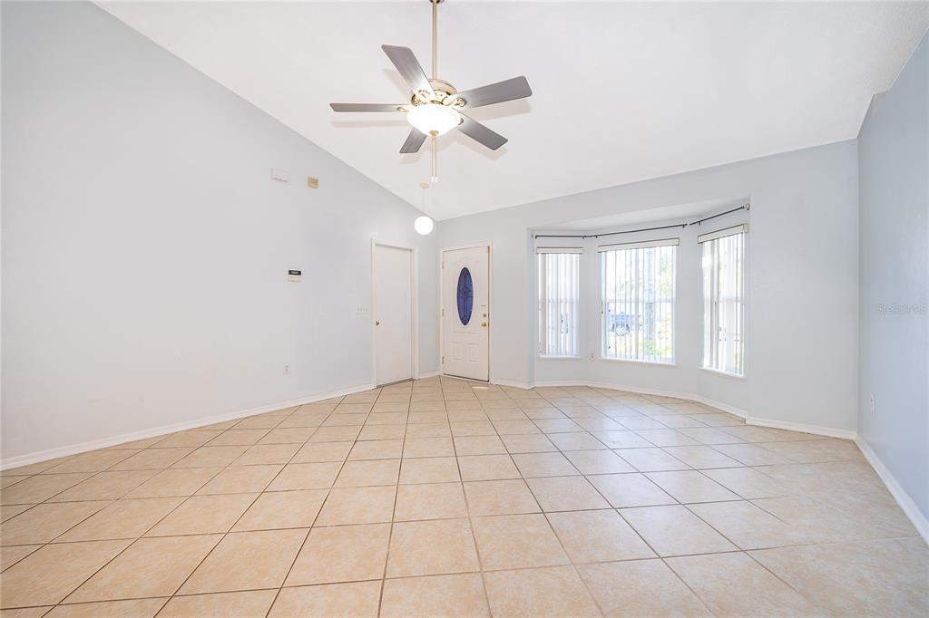 611 Baldwin Drive Kissimmee, FL 34758 - Photo 6 of 26 wooden floor in an empty room with a window