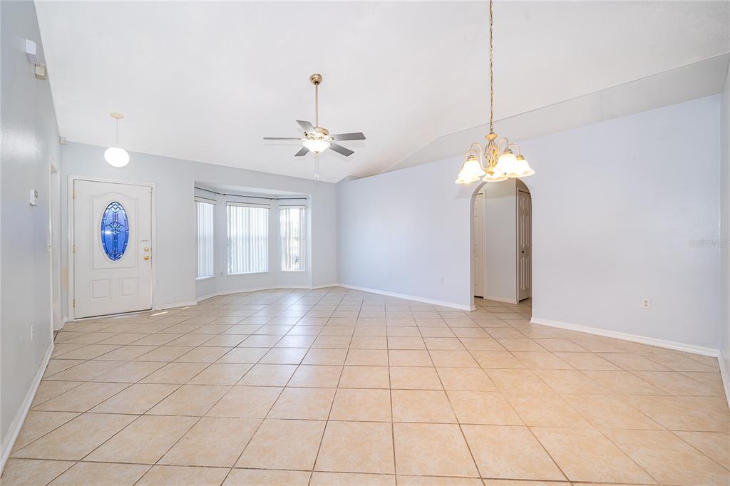 611 Baldwin Drive Kissimmee, FL 34758 - Photo 7 of 26 a view of an empty room with window and chandelier fan