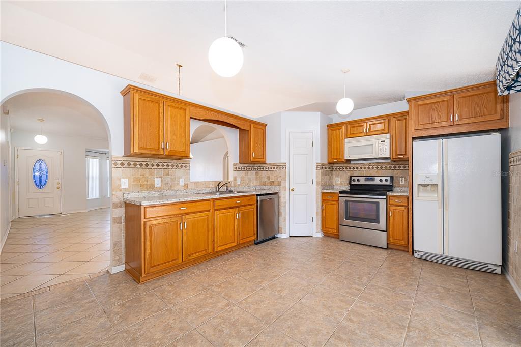 611 Baldwin Drive Kissimmee, FL 34758 - Photo 10 of 26 a kitchen with stainless steel appliances a refrigerator sink and stove