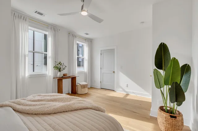a bedroom with a bed potted plant with the view of kitchen