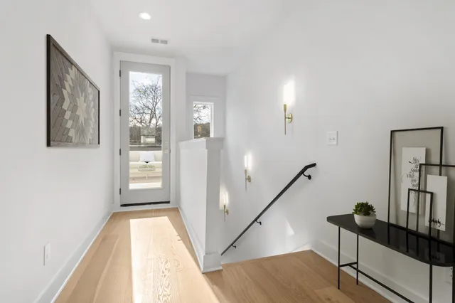 a view of hallway with windows and wooden floor