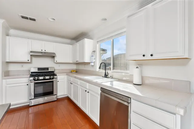 a kitchen with stainless steel appliances granite countertop a sink stove and cabinets