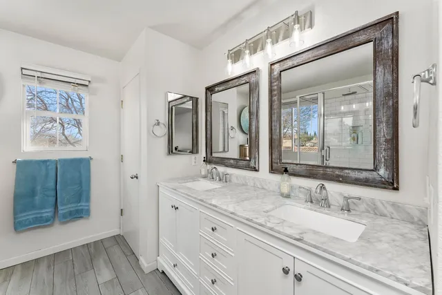 a bathroom with a granite countertop double vanity sink and a mirror